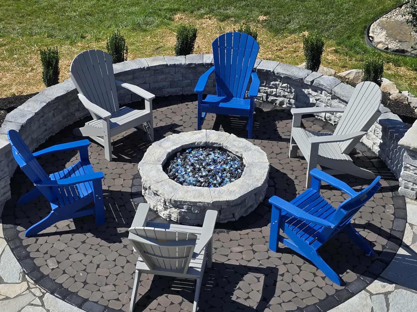 Circular fire feature with colorful Adirondack seating