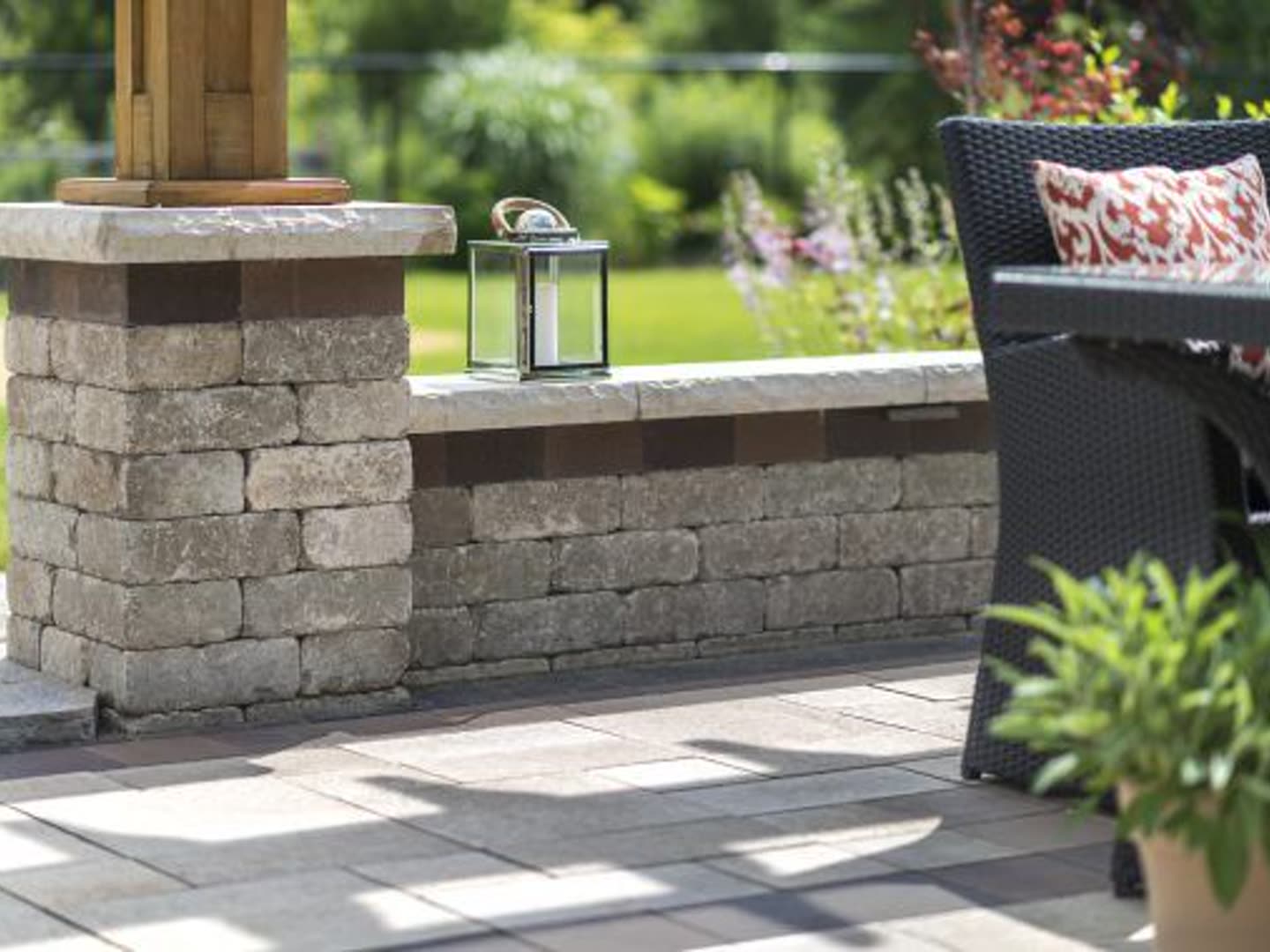 Stone retaining and seat wall beside a shaded patio