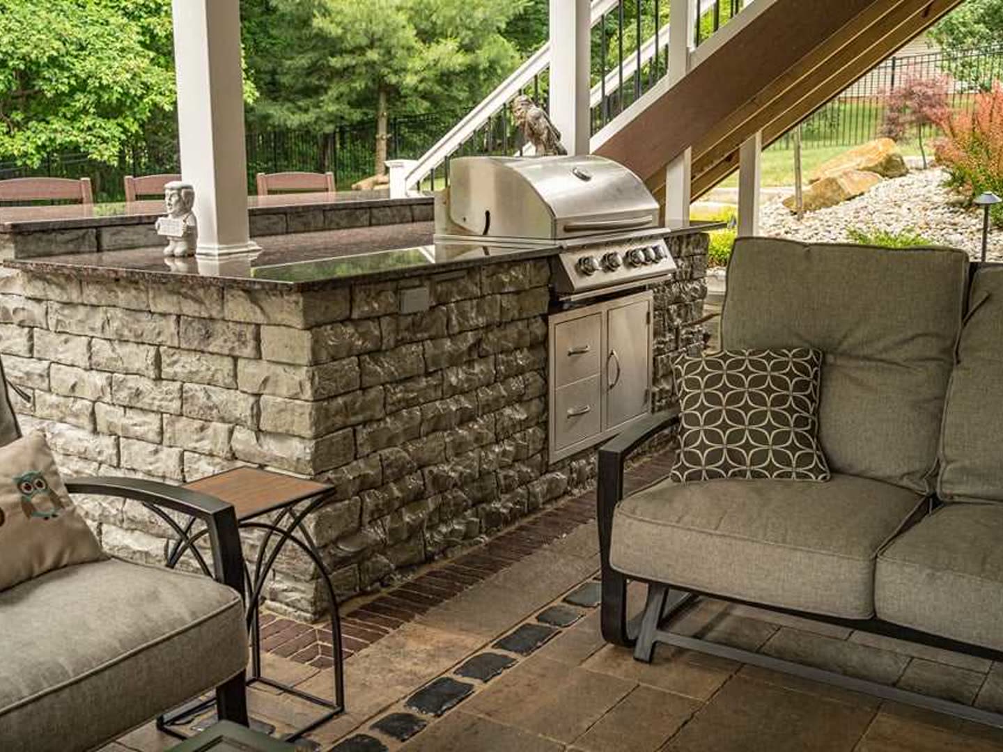 Built-in grill island with stone veneer and patio seating
