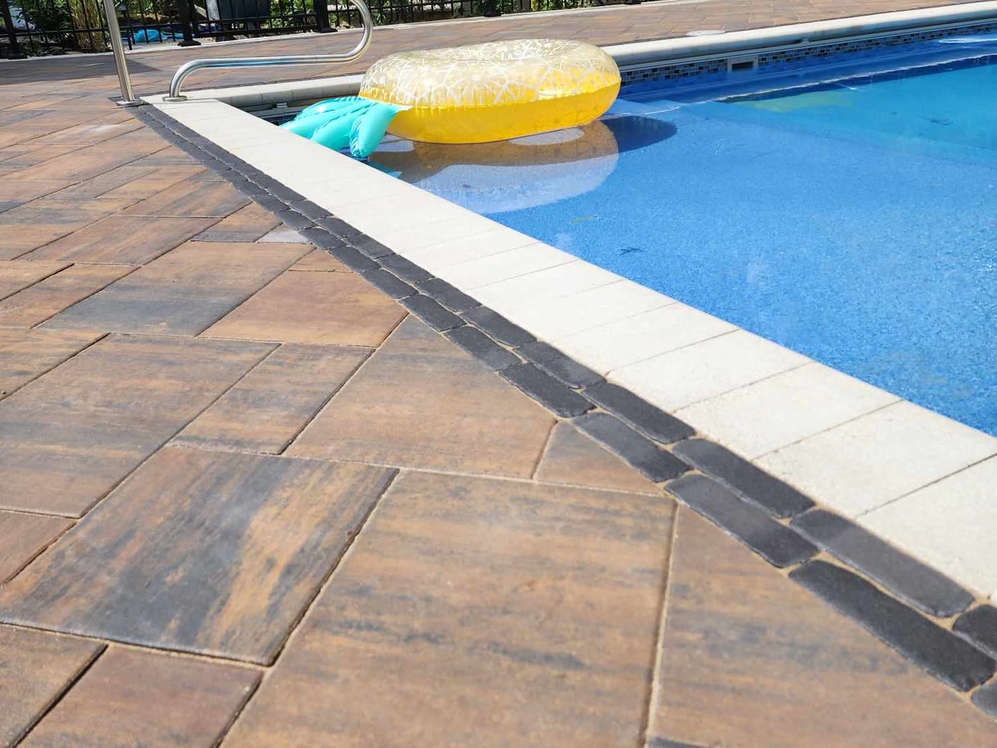 Pool deck with contrasting paver border and outdoor lounge area