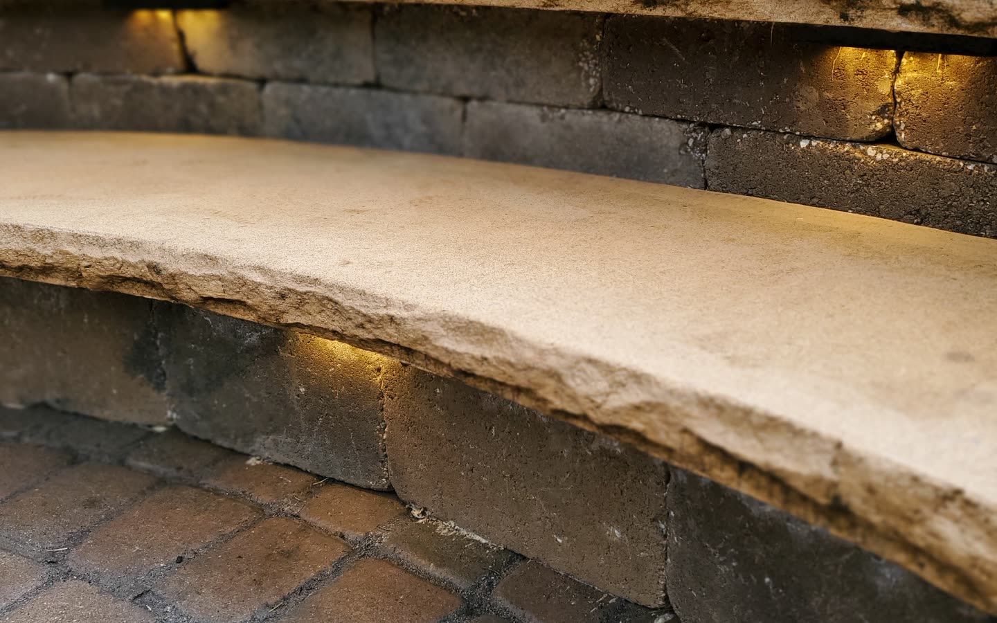 Curved stone retaining and seat wall with integrated lighting